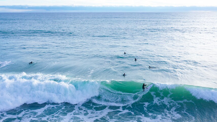 Aerial drone view of SUP surfer riding perfect Atlantic waves in the south coast of Spain doing...