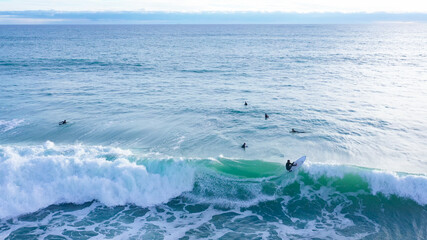 Aerial drone view of SUP surfer riding perfect Atlantic waves in the south coast of Spain doing...