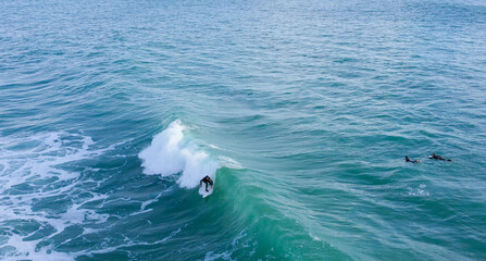 Aerial drone view of surfers riding perfect Atlantic waves in the south coast of Spain, Caños de...