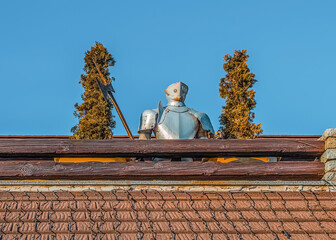 Knight armour on building between plants