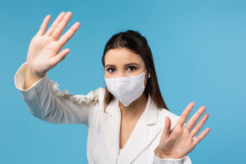 A girl office worker in a white shirt and a mask shows with her hands a stop at the camera, the end of the spread of the virus. The concept of work during quarantine.