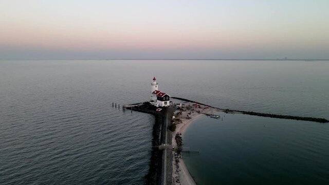Paard van Marken, lighthouse at sun set along the water in the Netherlands, near Amsterdam in Marken. Aerial drone view.
