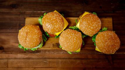 Set of pork burgers on wooden plate taken from top view