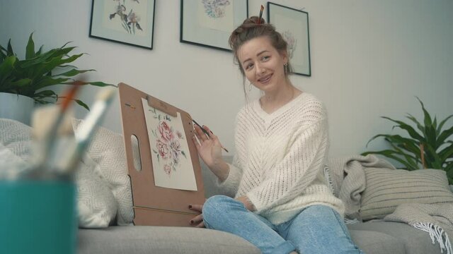 Streamer at home. Young female artist explaining her illustration.