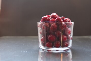 Food photo frozen cherries or cherries in a glass glass tableware on a black background with a place for text to eat a copyspace