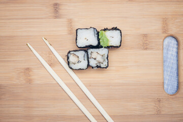 triangular sushi rolls chopsticks wooden background Japanese kitchen