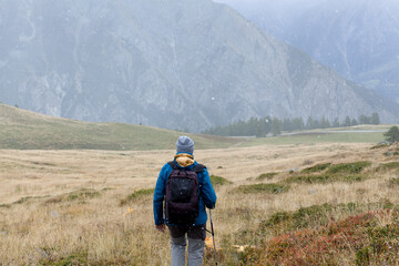 Obraz premium Traveler exploring mountains alone hiking with backpack adventure journey summer vacations traveling lifestyle weekend getaway Alpine mountain. Rear view