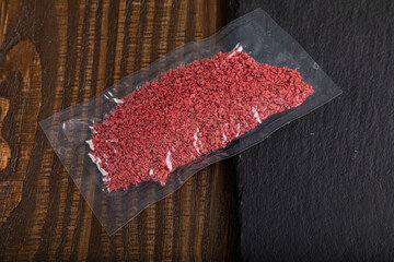 Crushed and dried raspberry flakes in vacuum sealed plastic bag
