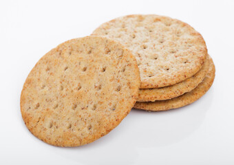 Stack of round organic crispy wheat  flatbread salty crackers on white. Top view