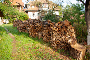 Stacks of firewood on the background of a village house.