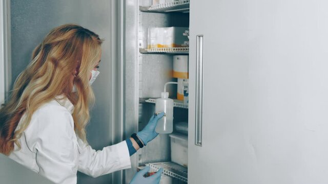 The doctor removes from the refrigerator the drug, which is stored at low temperatures.
