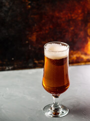 Glass of light beer on the table, rusty colorful iron background, vertical photo copy space