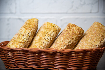 Russian colorful pancakes in a basket in a hole