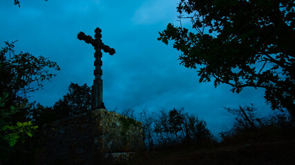 Contre plongée sur une croix en bois sous un ciel gris nuageux