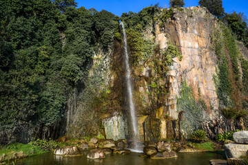 Jardin Extraordinaire, a garden in Nantes, France with a waterfall, rocks and lush vegetation.