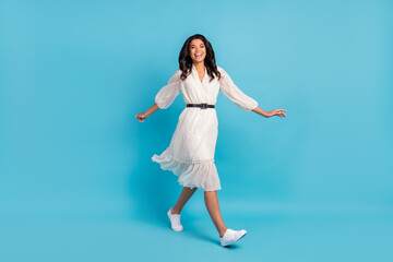 Full length body size view of attractive glad cheerful girl wearing midi dress going isolated over bright blue color background