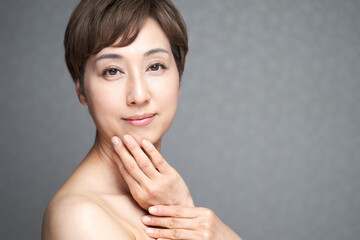 顎に手を当てる中年の日本人女性
