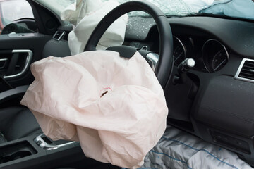 Interior of a automobile or car involved in a vehicle crash with a deployed steering column airbag