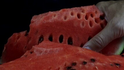 4K view of a hand taking a piece of ripe watermelon