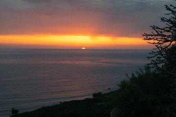 Fototapeta na wymiar Dramatic colorful sunset read and orange sky over the Atlantic Ocean in Punta Paloma, Tarifa, Spain