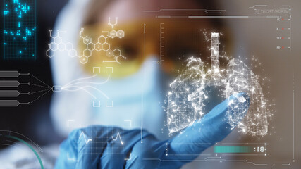 Young female doctor in eyeglasses and protective mask looking at 3d lungs model. Coronavirus. Futuristic technology. Medicine concept. Human health care. Lung infecting process. Medical innovation.
