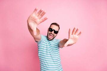 Portrait of nice cheerful content cool guy wearing sunglasses having fun dancing flirting isolated over pink pastel color background