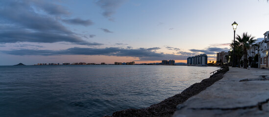 seashore of La Manga del Mar Menor with ist many hotels and beaches at sunset under an expressive sky