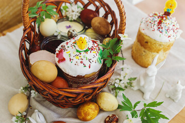 Traditional Easter food, homemade Easter bread,  easter eggs and spring flowers on rustic table