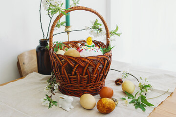 Fototapeta na wymiar Easter food, eggs, beets, cheese, butter, ham, Easter bread in basket with flowers on rustic table
