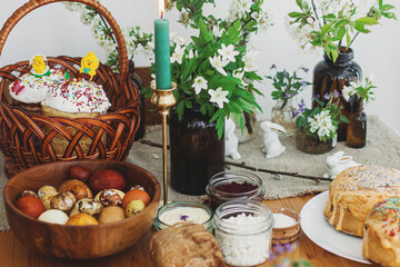Traditional Easter food, homemade Easter bread,  easter eggs and spring flowers on rustic table