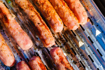 Sausages meat grilling on gas grill