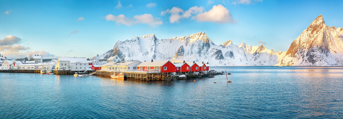 Traditional Norwegian red wooden houses (rorbuer) on the shore of  Reinefjorden near Hamnoy village.