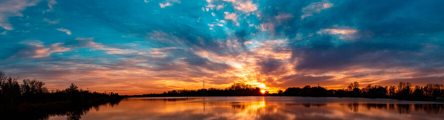 High resolution stitched panorama of a beautiful autumn or indian summer sunset with reflections...