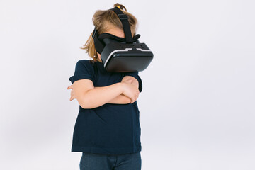 Little girl wearing virtual reality glasses with arms crossed, on white background