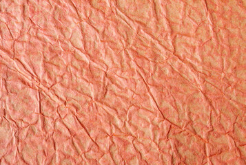 Fototapeta premium Close-up of vintage crumpled paper. Orange-brown paper with wrinkles for background