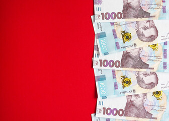 One thousand Ukrainian hryvnia banknotes on a red background 2