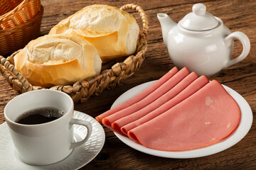 Sliced ​​mortadella with breads on the table.