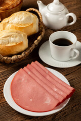 Sliced ​​mortadella with breads on the table.