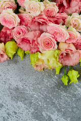 pink eustoma and rose flowers on stone surface
