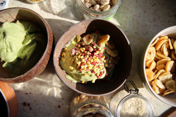 Healthy smoothy in a ceramics and coconut bowls. Vegan diet with fruit and nuts. Healthy lifestyle.Wooden texture. Home cooking. 