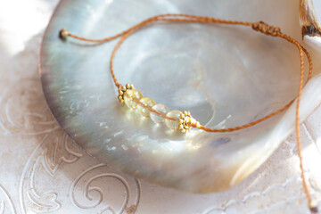 Citrine gemstone beads tiny elegant bracelet on natural shell background - 419843296