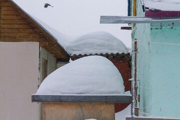 Large mountains of snow on dacha buildings in winter
