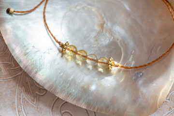 Citrine gemstone beads tiny elegant bracelet on natural shell background