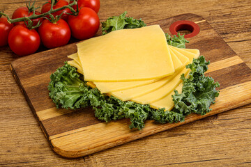 Sliced Gauda cheese over board