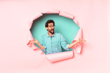 young crazy bearded man. happy and surprised expression. paper hole empty background concept