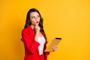 Portrait of her she nice attractive glamorous minded wavy-haired lady using tablet deciding overthinking strategy growth isolated on bright vivid shine vibrant yellow color background