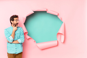 young crazy bearded man. thinking or doubting expression. paper hole empty background concept