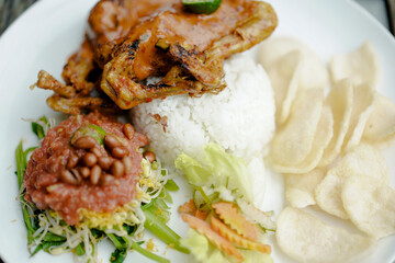 Ayam Taliwang food, special food is young smoked chicken, spiced and then burned, and chili or plecing water spinach. Indonesia food
