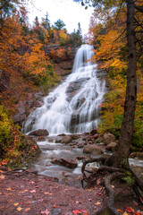Gushing water fall in an autumn forest landscape with dense trees, Cape Breton. Autumn waterfall view. Beulach Ban Falls, Nova Scotia, Canada