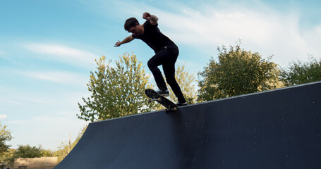Young male adult skateboarding halfpipe miniramp grinding and makes tricks